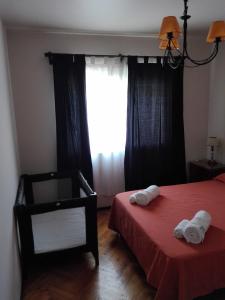 1 dormitorio con 2 camas, silla y ventana en Colon Apartment en Mendoza