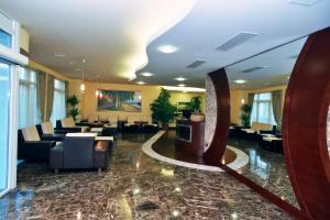 a lobby with a waiting room with couches and tables at Hotel Savus in Slavonski Brod