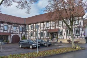 a building with two cars parked in front of it at Hotel Ristorante Rostica in Bad Urach