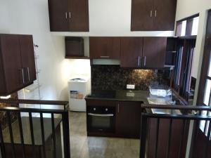a kitchen with dark brown cabinets and a stove at Rivers Edge Residencies in Peliyagoda Pattiya