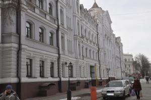 a large white building with a car parked in front of it at Apartments Theatre Shepkina 2 room in Sumy