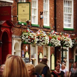a crowd of people walking in front of a building with flowers at Galtres Lodge Hotel & Forest Restaurant in York