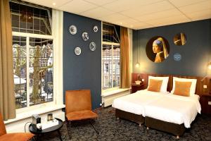 Una habitación de hotel con una cama y dos ventanas. en Hotel de Koophandel, en Delft