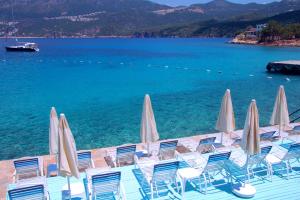 a group of chairs and umbrellas on a dock with the water at La Moda Beach Hotel in Kaş