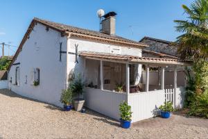 a white cottage with a palm tree in front of it at Le Petit Bouchon in Parcoul