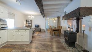 a kitchen with a stove and a living room at Le Petit Bouchon in Parcoul