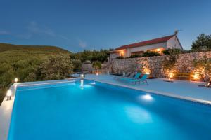 a villa with a swimming pool at night at Villa Serenity in Hvar