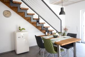 une salle à manger avec une table et un escalier dans l'établissement Zur alten Rebe Ferienhaus und Weingut, à Konz