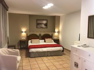 une chambre d'hôtel avec un lit et un canapé dans l'établissement Hotel Patri, à Huéscar