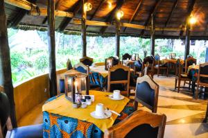 ein Esszimmer mit Tischen, Stühlen und einem Tischler in der Unterkunft Ankobra Beach Resort in Axim