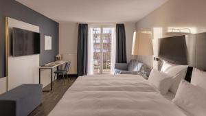 a hotel room with a large bed and a desk at Hotel the YARD Bad Honnef in Bad Honnef am Rhein