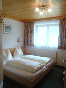 um quarto com uma cama grande em frente a uma janela em Haus Zirmblick em Saalbach-Hinterglemm