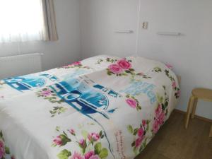 Una cama con flores en un dormitorio en Chalet Seazon R23, en Buren