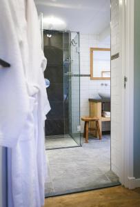 een badkamer met een glazen douche en een wastafel bij Logement ‘t Voorhuysch in Ingen