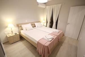 a bedroom with a large bed with white sheets and pillows at Villa Sirena in Xerokampos