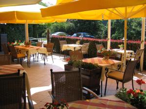 um restaurante com mesas e cadeiras e um guarda-sol amarelo em Hotel Molnár em Budapeste