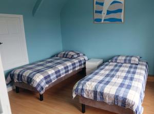 2 Betten in einem Zimmer mit blauen Wänden in der Unterkunft 31 Chemin de la Croix aux Outils in Paimpol