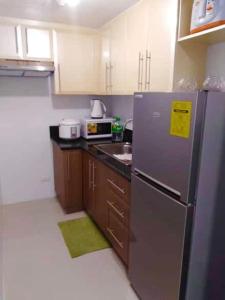 een kleine keuken met een koelkast en een wastafel bij Ameer Condotel @ Parkside Villa in Manilla