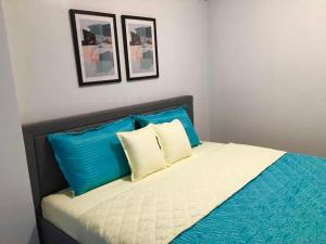 een bed met blauwe en witte kussens in een slaapkamer bij Ameer Condotel @ Parkside Villa in Manilla +18 foto's