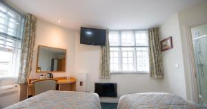 a bedroom with a bed and a television on the wall at Fox Connaught London ExCel in London