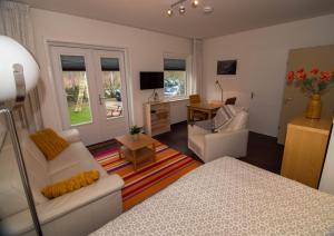 een woonkamer met een witte bank en een tafel bij De Vier Berken 2 in De Koog