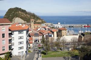 a view of a town with a harbor and the ocean at BALENTZIAGA Getaria in Getaria