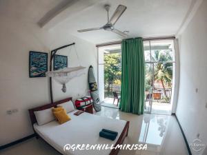 a bedroom with a bed and a large window at Green Hill Mirissa in Mirissa