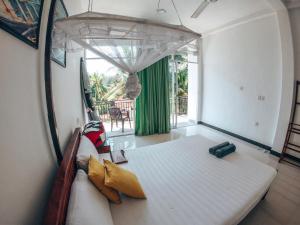 a bed in a room with a large window at Green Hill Mirissa in Mirissa