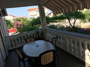 a porch with a table and chairs on a balcony at Apartments Stancic in Vodice