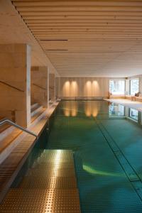 uma piscina interior com uma piscina verde em Hotel Sonnenburg em Lech am Arlberg