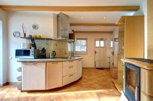 a large kitchen with a microwave and a stove at Kotedzas Nidoje in Nida