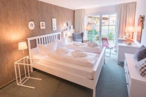 a bedroom with a white bed and a window at Hotel Auszeit in Isernhagen