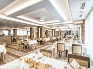 jadalnia z białymi stołami i krzesłami w obiekcie Hotel Familia w mieście Lubowla