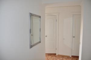 a mirror on a white wall in a room at Apartments Theatre Shepkina 2 room in Sumy