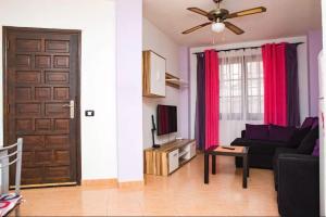 ein Wohnzimmer mit Sofa und Tür in der Unterkunft Los Cristianos Tenerife in Los Cristianos