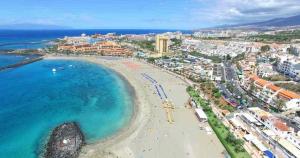 eine Luftansicht auf einen Strand und das Meer in der Unterkunft Los Cristianos Tenerife in Los Cristianos