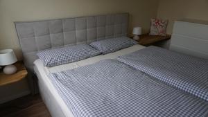 a bed with blue and white sheets and pillows at Kiteblick in Büsum