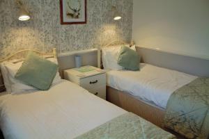 two beds in a small room with at Darcey's Apartment in Bowness-on-Windermere