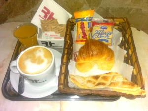 un vassoio con prodotti per la colazione e una tazza di caffè di Real Horizonte Hotel -Motel- a Don Torcuato