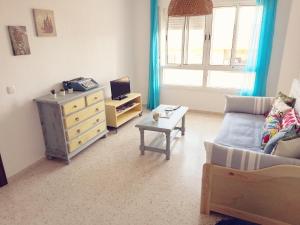 uma sala de estar com um sofá e uma cómoda em Vivienda cercana a la playa con todas las comodidades em Tarifa