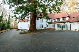 a large white house with a tree in the driveway at Burnside Hotel in Stratford-upon-Avon