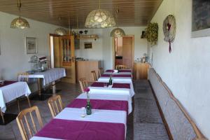 a row of tables in a restaurant with purple table cloth at Gästehaus am Muttelsee in Tettnang