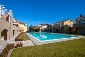 a swimming pool in a yard next to some houses at Residence Fornaci in Peschiera del Garda