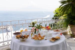 una mesa con comida en un balcón con vistas al océano en Villa Silvana Relais, en Sorrento