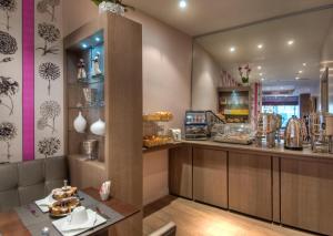 a restaurant with a counter with pastries at Hotel Massena in Paris
