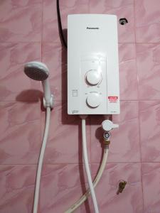 a white electrical outlet with a cord plugged into it at Homestay Haji Hamid in Pantai Cenang