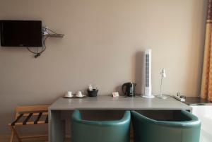 a dining room table with two chairs and a microwave at Hotel Castel in Ghent