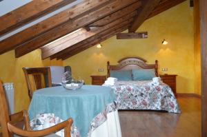 sypialnia z łóżkiem i stołem w pokoju w obiekcie Hotel Rural El Marqués w mieście Saldaña
