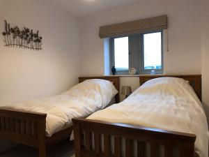 two beds sitting next to each other in a room at Pepperpot Cottage in Skipton