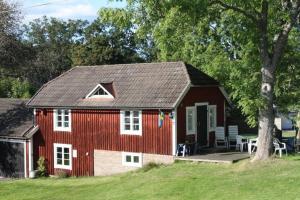 a red barn with a porch and a table at MY LITTLE BED & BREAKFAST & HOLIDAY HOME in Älghult